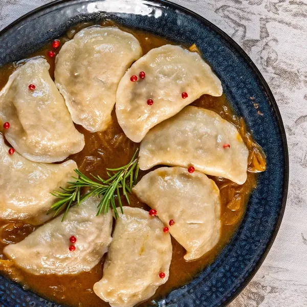 Ręcznie lepione pierogi z Wyszynku na drewnianej stolnicy