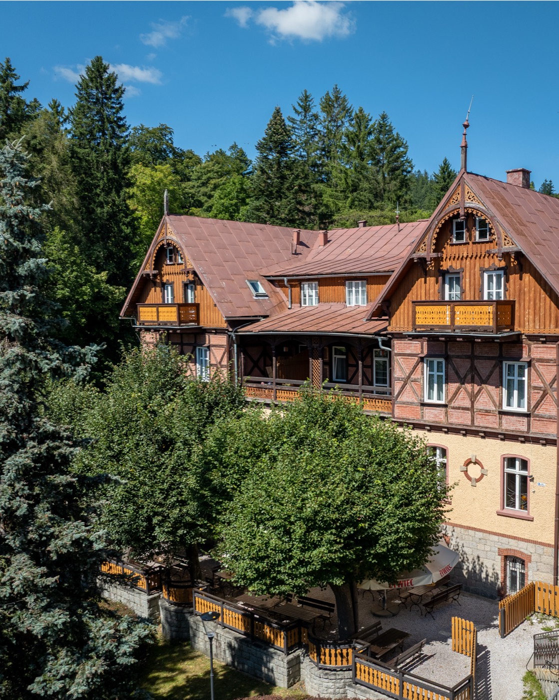 Historyczna fasada budynku dawnego Hotelu Klose, dziś Villa Bożena, otoczona lasem Karkonoszy
